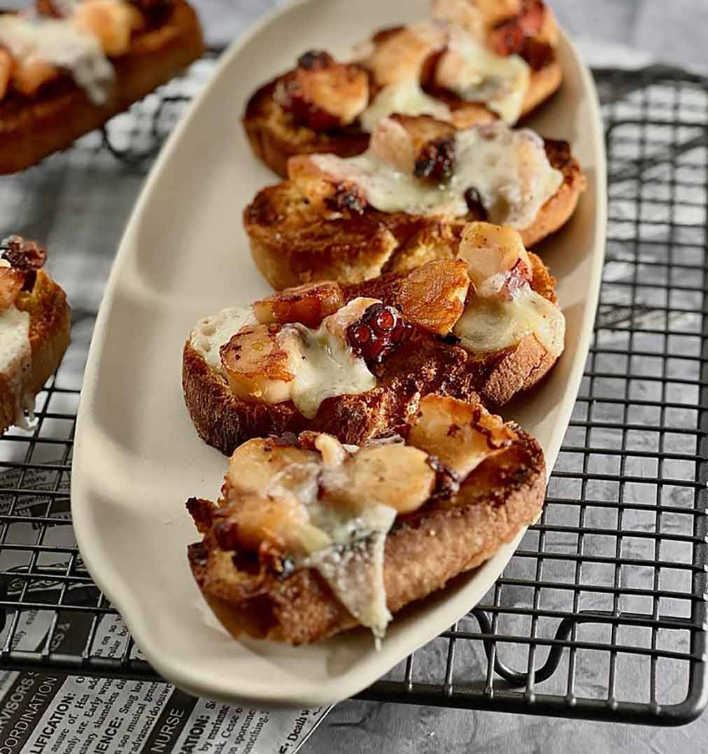 Aperitivo de tostas de pulpo y queso
